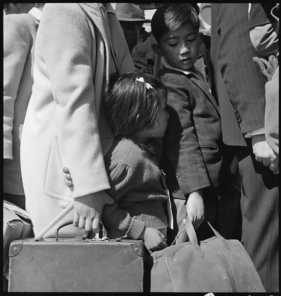 Third generation Japanese-American children awaiting the arrival of the next bus. Byron, California 1942. By Dorothea Lange (Source: commons.wikimedia.org)